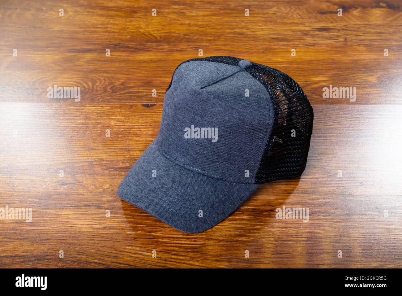 Composition of close up of grey and black baseball cap on wooden background Stock Photo