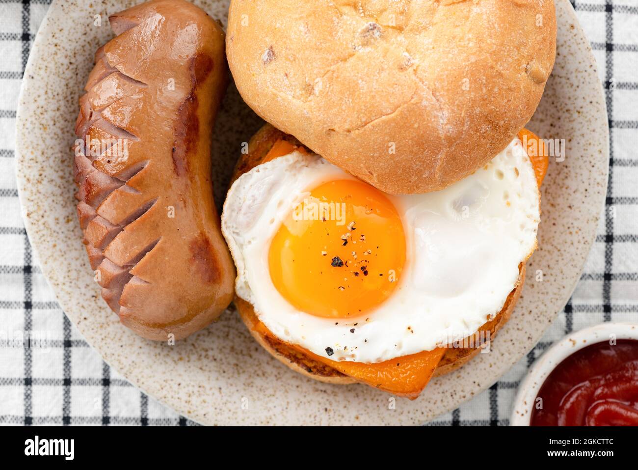 English muffin with egg cheese and sausage on plate, top view Stock Photo