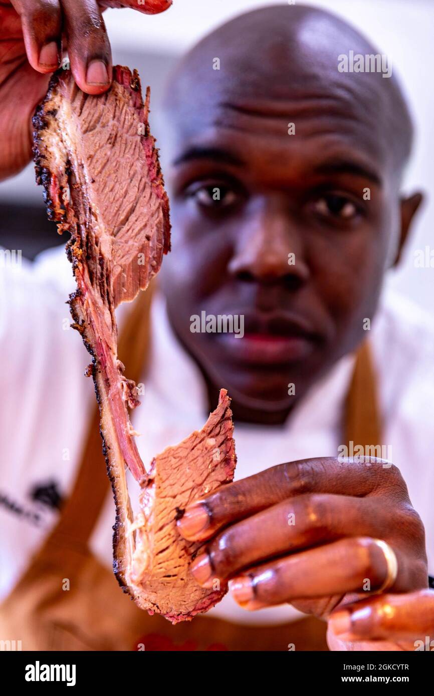 Sgt. Alexander C. Jones, Marine enlisted aide, Marine Forces Reserve, prepares brisket at Marine Corps Support Facility, New Orleans, Mar. 16, 2021. Jones is representing the Marine Corps for the 2021 USO Metro BBQ Battle. Stock Photo