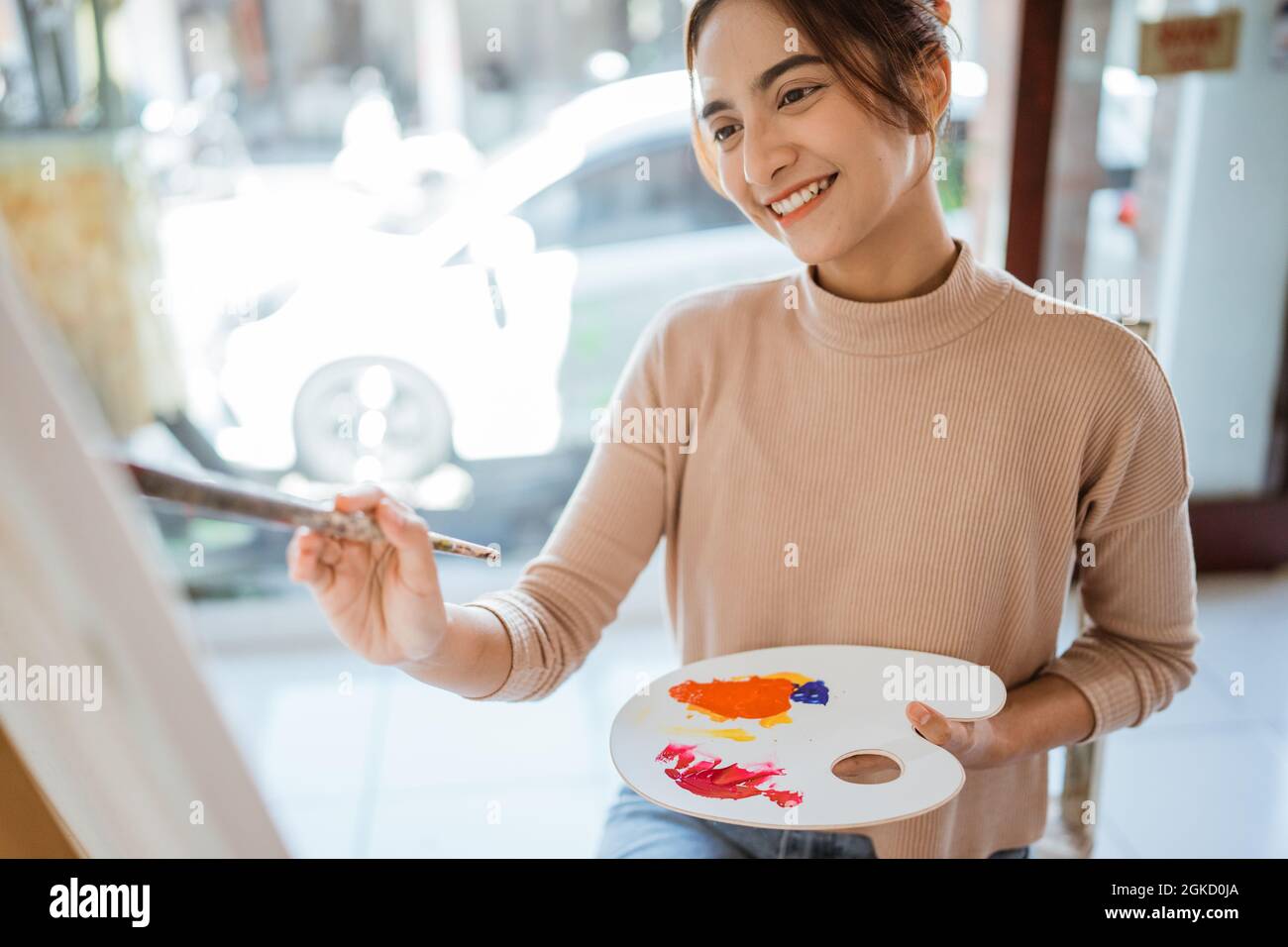 asian female artist painting on canvas doing some art projects on her ...