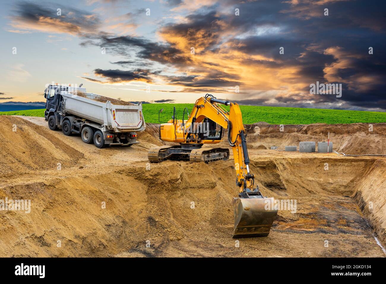 excavator working on construction site with dramatic clouds on sky ...