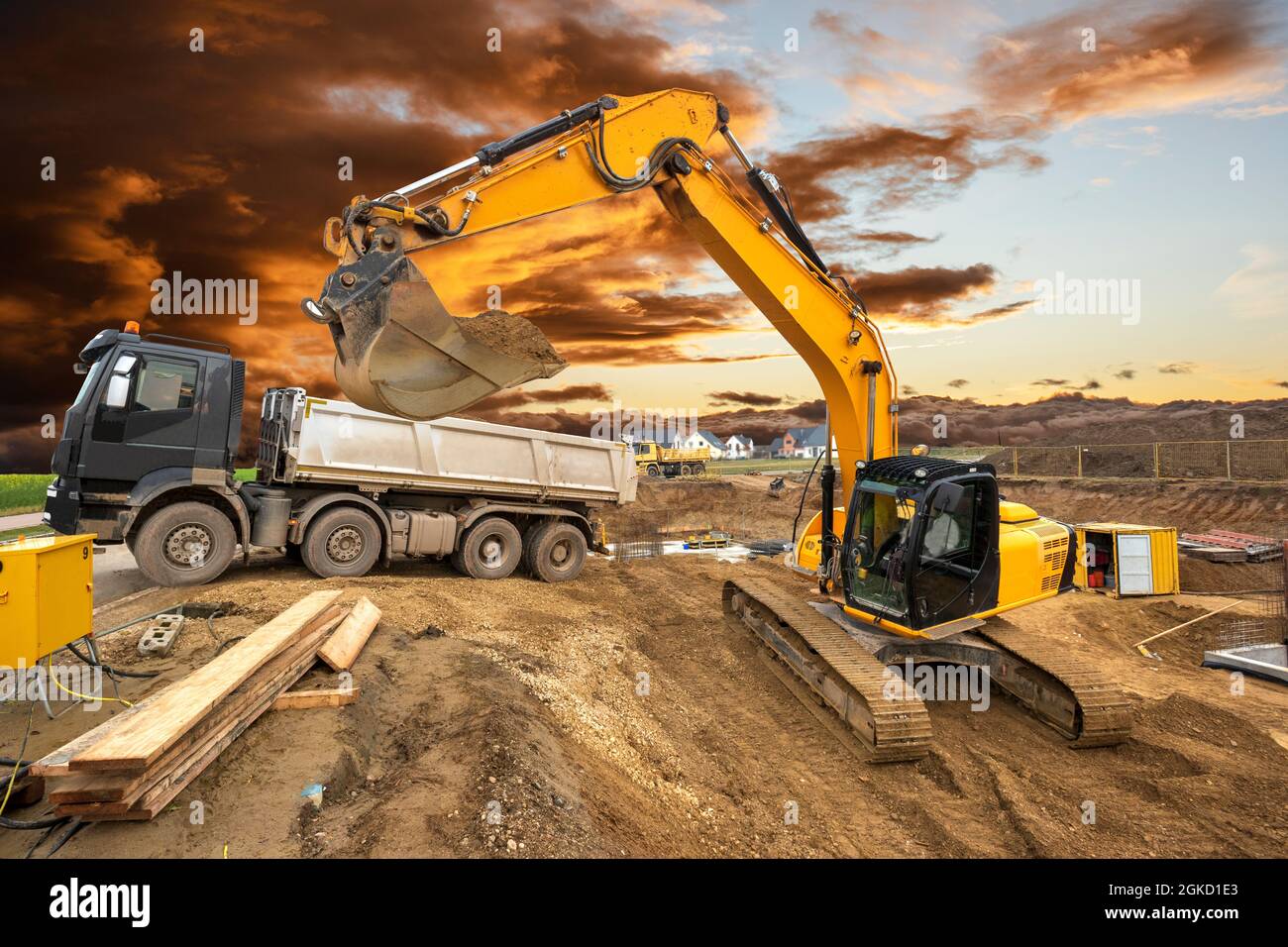 excavator working on construction site with dramatic clouds on sky ...