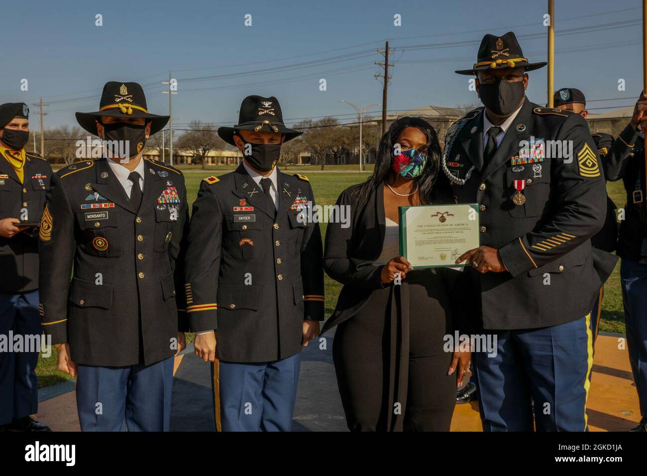 Col. Neil Snyder, 1st Cavalry Division Artillery commander and Command Sgt. Maj. Edgar Monsanto, 1st Cavalry Division Artillery command sergeant major, stand beside First Sergeant Paul E. Joseph and his wife, Veronica, during the division's Distinguished Service Recognition Ceremony on Cooper Field, Fort Hood, TX, March 17, 2021. Joseph received the Meritorious Service Medal for his more than 21 years of service. Stock Photo