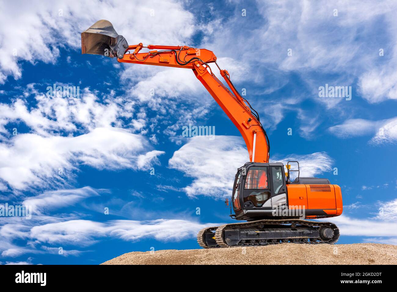excavator working on construction site with dramatic clouds on sky ...