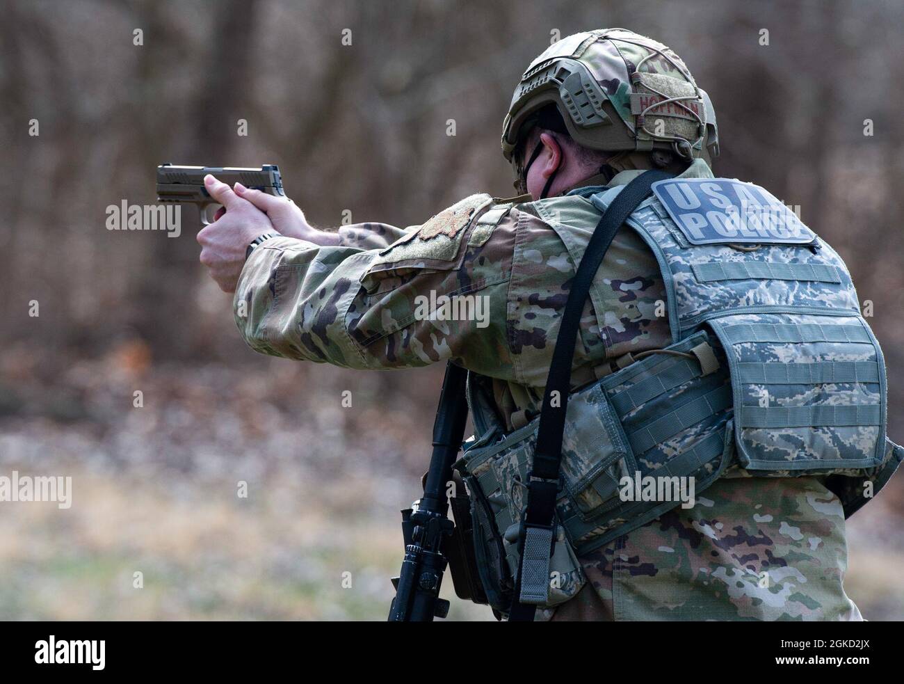 A member of the 88th Security Forces Squadron aims an M18 pistol at a ...