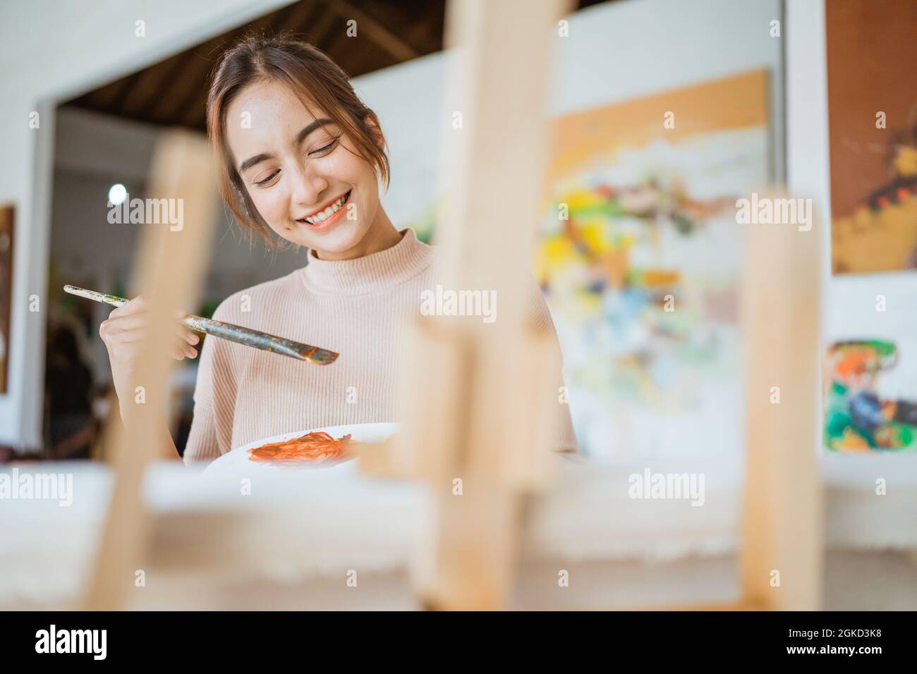 asian female artist painting on canvas doing some art projects on her ...