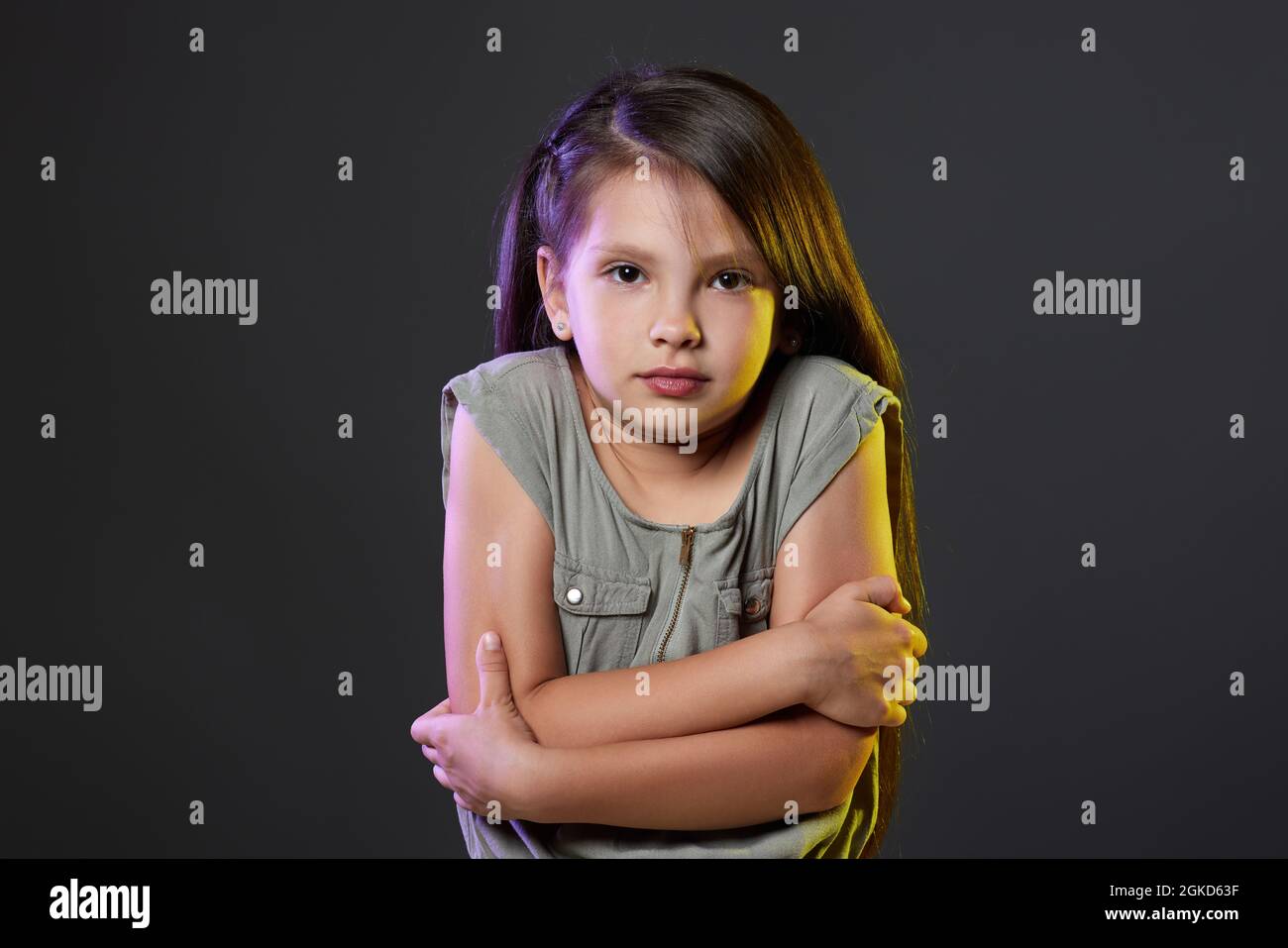 Unhappy little child girl feel cold on dark background Stock Photo