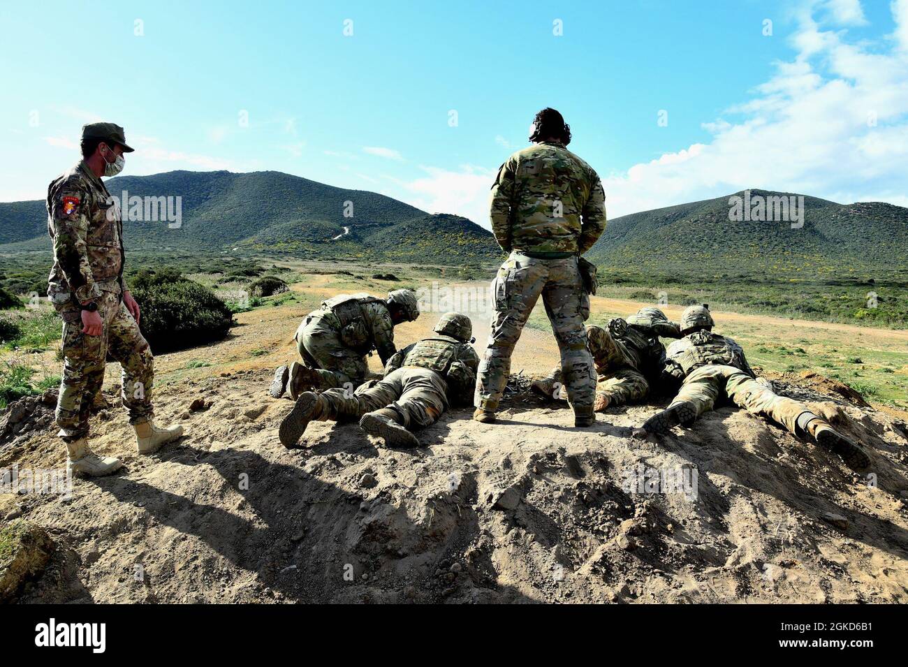 (Left) Italian paratrooper Maj. Giovanni Agosti liaison officer G3 branch SETAF Ederle Vicenza, observes the U.S. Army paratroopers assigned to Legion Company, 1-503rd Infantry Regiment,  173rd Airborne Brigade during M240 machine gun long range marksmanship as part of Eagle Pangea in the Italian Army Capo Teulada Major Training Area on the island of Sardinia, Italy Mar. 18, 2021 under Covid-19 prevention conditions. Exercise Eagle Pangea is a 1-503rd IN squad live fire and platoon external evaluation training event. The 173rd Airborne Brigade is the U.S. Army's Contingency Response Force in E Stock Photo