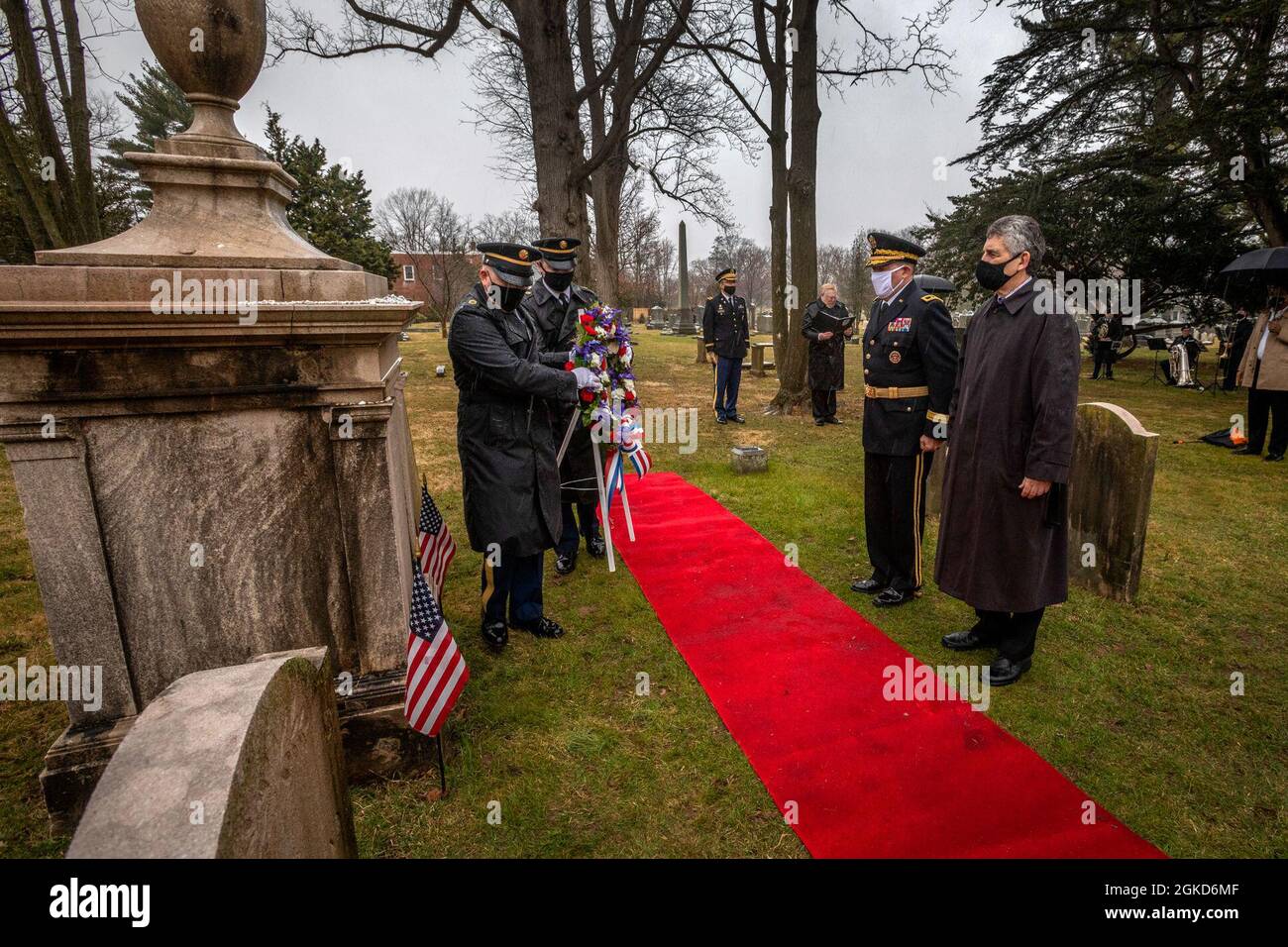 U.S. Army Honor Guard Soldiers with the 99th Readiness Division, U.S. Army Reserve, carry a memorial wreath to President Grover Cleveland’s grave at Princeton Cemetery, Princeton, N.J., March 18. 2021. The ceremony commemorated President Cleveland’s 184th birthday. The Presidential Wreath Laying Program is administered by the White House Military Office, which is responsible for coordinating the annual placement of presidential wreaths at the tombs and resting places of former presidents, other famous Americans, and at certain memorials of historical significance. Stock Photo