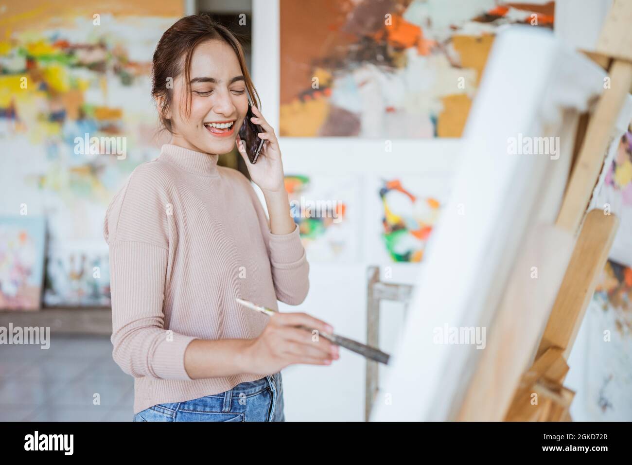 asian female artist painting on canvas doing some art projects on her ...