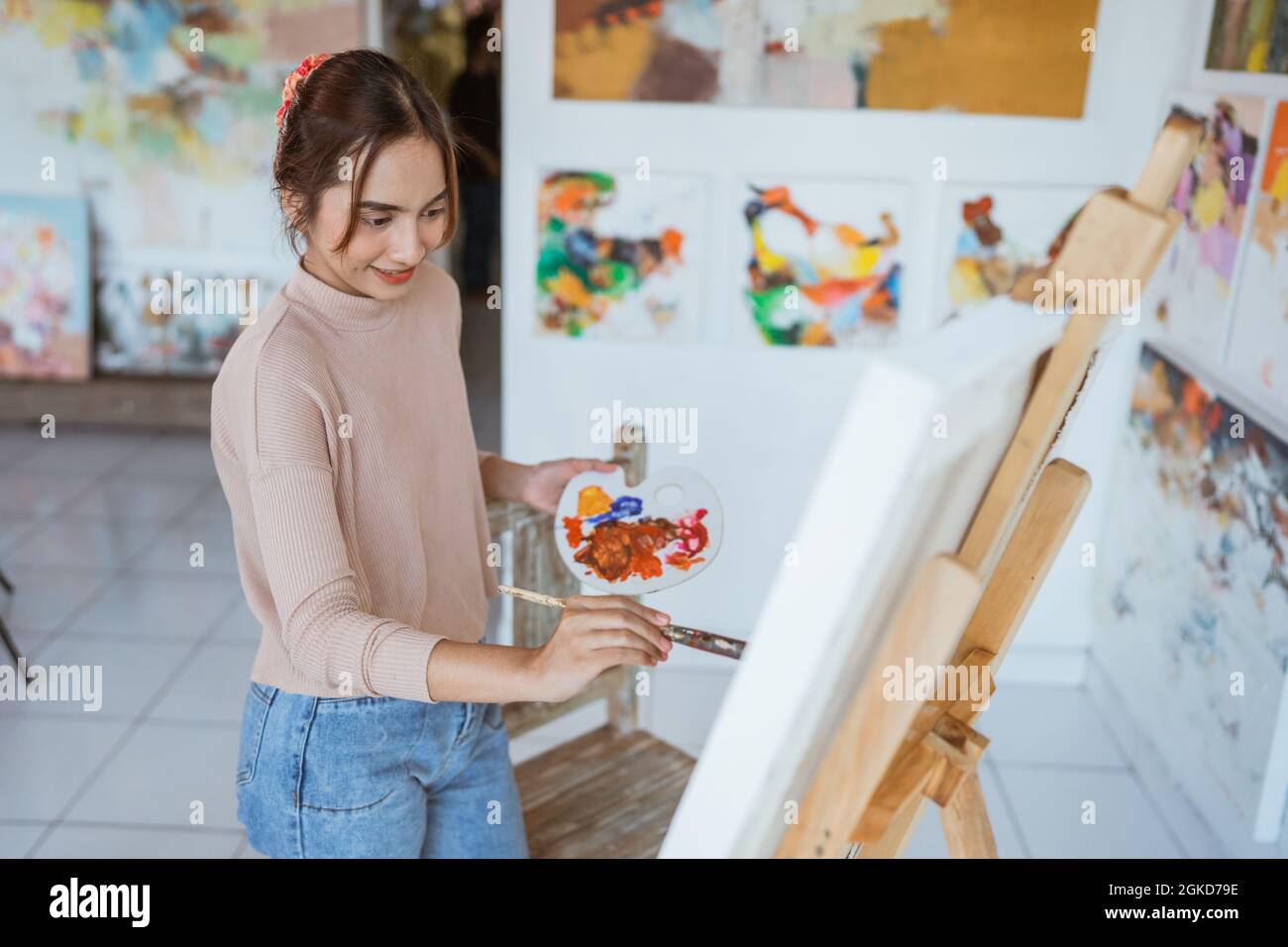 asian female artist painting on canvas doing some art projects on her ...