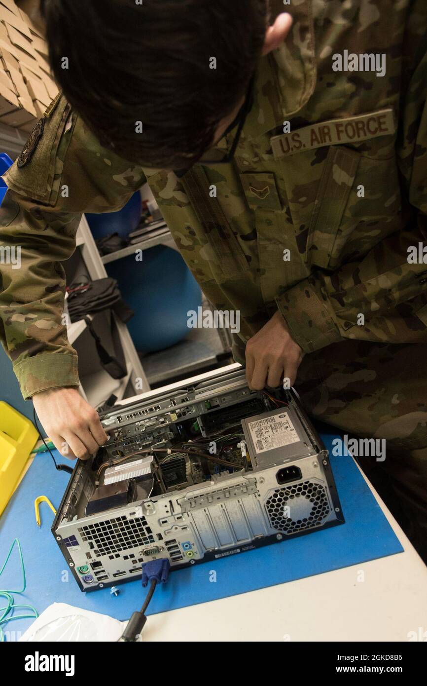 U.S. Air Force Airmen 1st Class Cade Hammerling, a Client Systems Technician assigned to the 509th Communication Squadron, places parts into a computer at Whiteman Air Force Base, Missouri, March 18, 2021. Hammerling helps provide support and mange communication systems through effective troubleshooting, repair and system performance analysis. Stock Photo