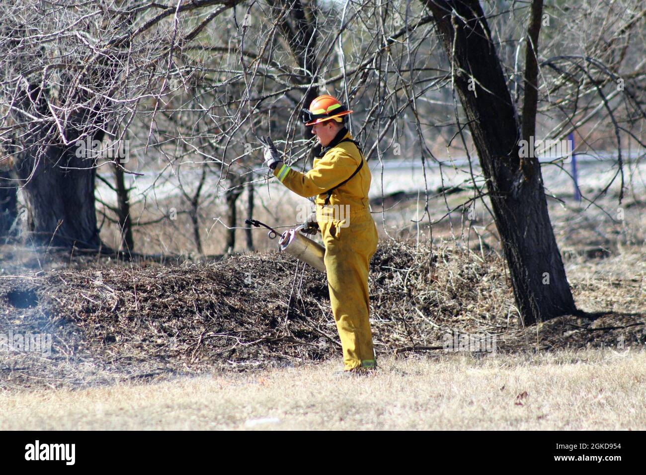 Forestry Technician Tim Parry lights a prescribed burn March 18, 2021, along the railroad tracks on South Post at Fort McCoy, Wis. The post prescribed burn team includes personnel with the Fort McCoy Directorate of Emergency Services Fire Department; Directorate of Public Works (DPW) Environmental Division Natural Resources Branch; Directorate of Plans, Training, Mobilization and Security; and the Colorado State University Center for Environmental Management of Military Lands, under contract with the post. Prescribed burns also improve wildlife habitat, control invasive plant species, restore Stock Photo