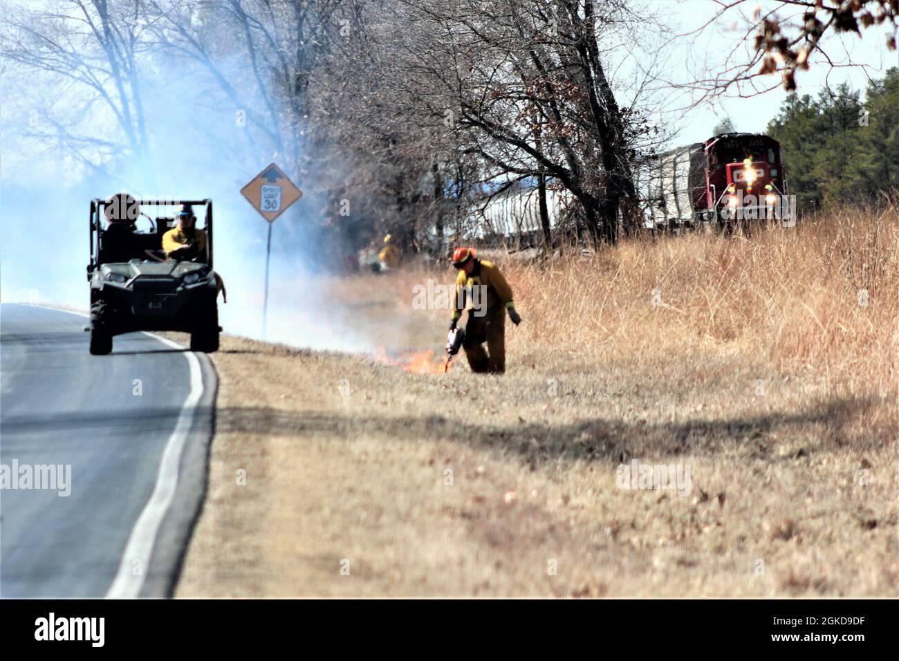 Forestry Technician Tim Parry lights a prescribed burn March 18, 2021, along the railroad tracks on South Post at Fort McCoy, Wis. The post prescribed burn team includes personnel with the Fort McCoy Directorate of Emergency Services Fire Department; Directorate of Public Works (DPW) Environmental Division Natural Resources Branch; Directorate of Plans, Training, Mobilization and Security; and the Colorado State University Center for Environmental Management of Military Lands, under contract with the post. Prescribed burns also improve wildlife habitat, control invasive plant species, restore Stock Photo