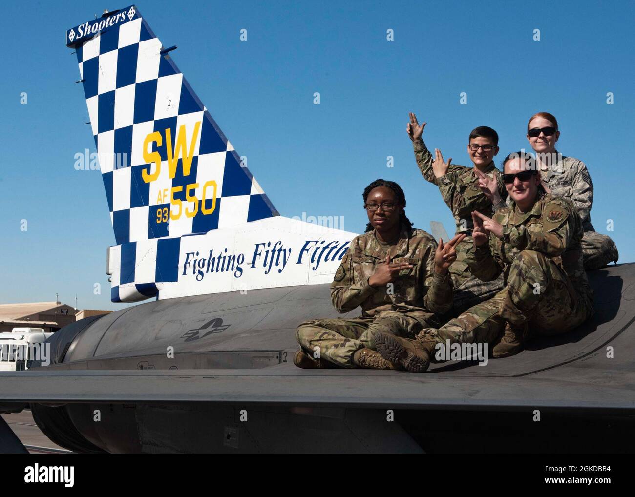 Female Airmen pose on the side of an F-16 Fighting Falcon for Women's History Month at Nellis Air Force Base, Nevada, March 19, 2021. The Airmen participated in the Air Force's most premier combat training exercise, Red Flag. Stock Photo