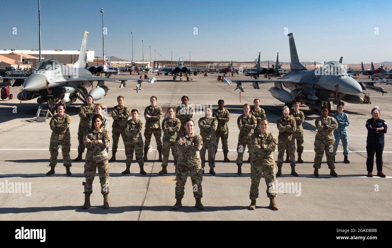 Female service members stand on the flightline for Women's History Month at Nellis Air Force Base, Nevada, March 19, 2021. The service members participated in the Air Force's two-week advanced aerial combat training exercise, Red Flag. Stock Photo