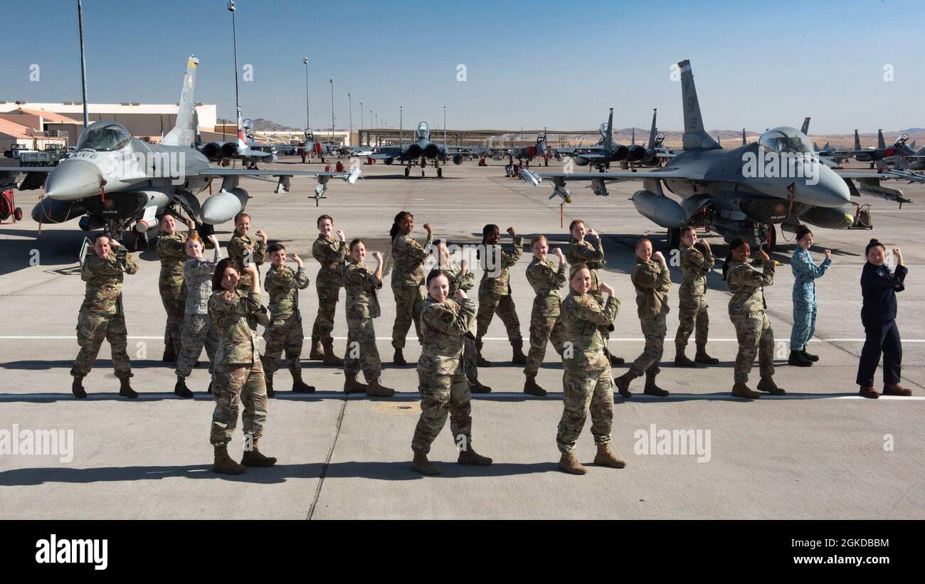 Female service members do the Rosie the Riveter pose for Women's History Month at Nellis Air Force Base, Nevada, March 19, 2021. The service members participated in the Air Force's two-week advanced aerial combat training exercise, Red Flag. Stock Photo