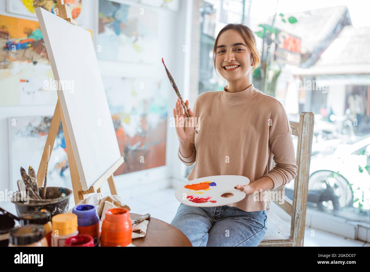 asian female artist painting on canvas doing some art projects on her ...