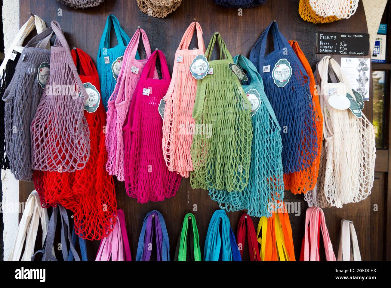 A range of string shopping bags in numerous colours but all of a similar  design, hanging on display in a tourist gift shop in France. (127 Stock  Photo - Alamy