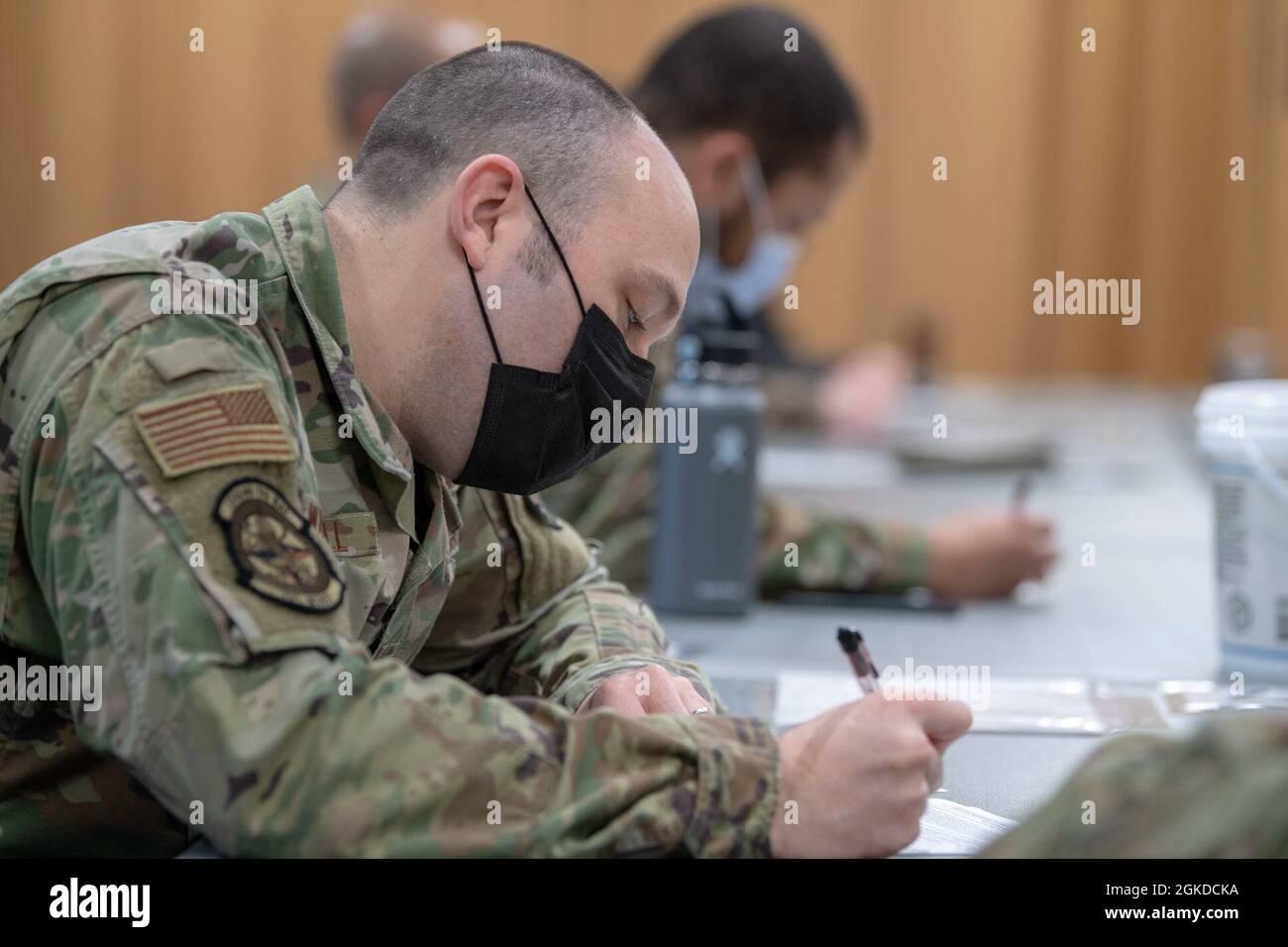 Airmen assigned to the 701st Munitions Maintenance Squadron complete paperwork before being administered the COVID-19 vaccine at Kleine Brogel Air Base, Belgium, March 19, 2021. These vaccines were administered by independent duty medical technicians who are responsible for providing all the medical care for members assigned to the 701st MUNSS. Stock Photo