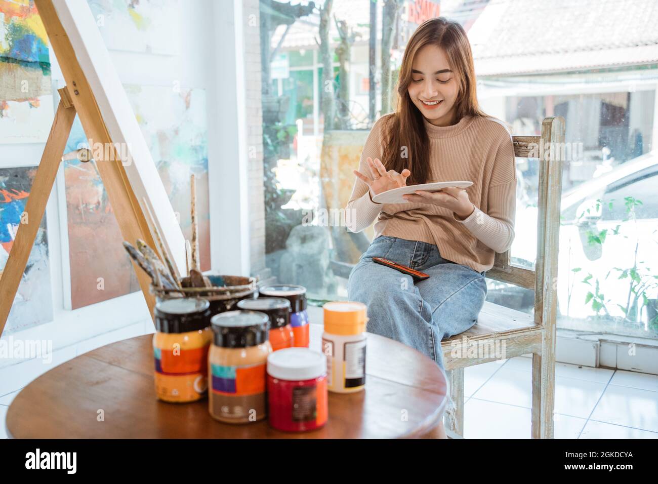 asian female artist painting on canvas doing some art projects on her ...