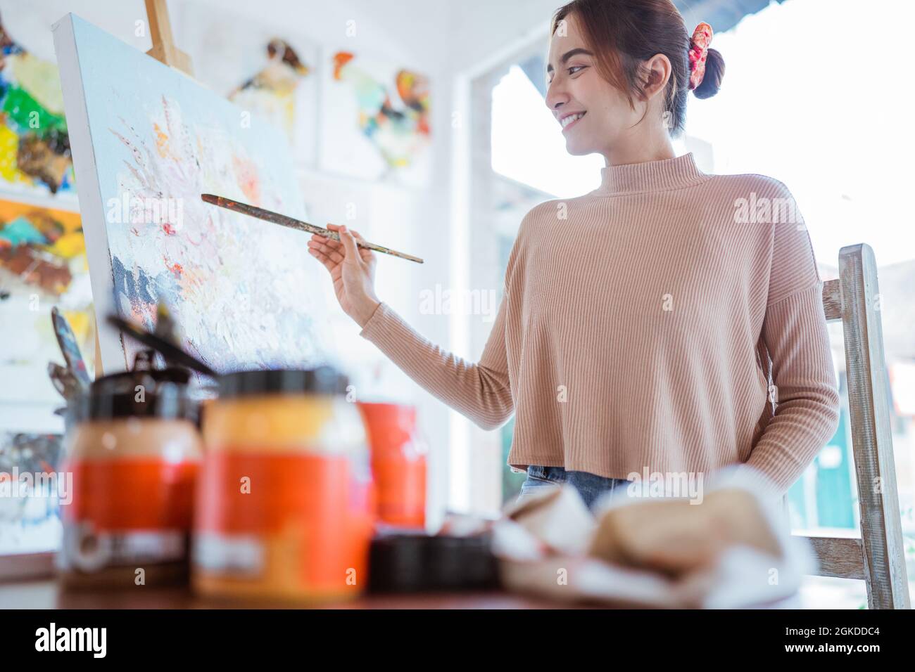 asian female artist painting on canvas doing some art projects on her ...