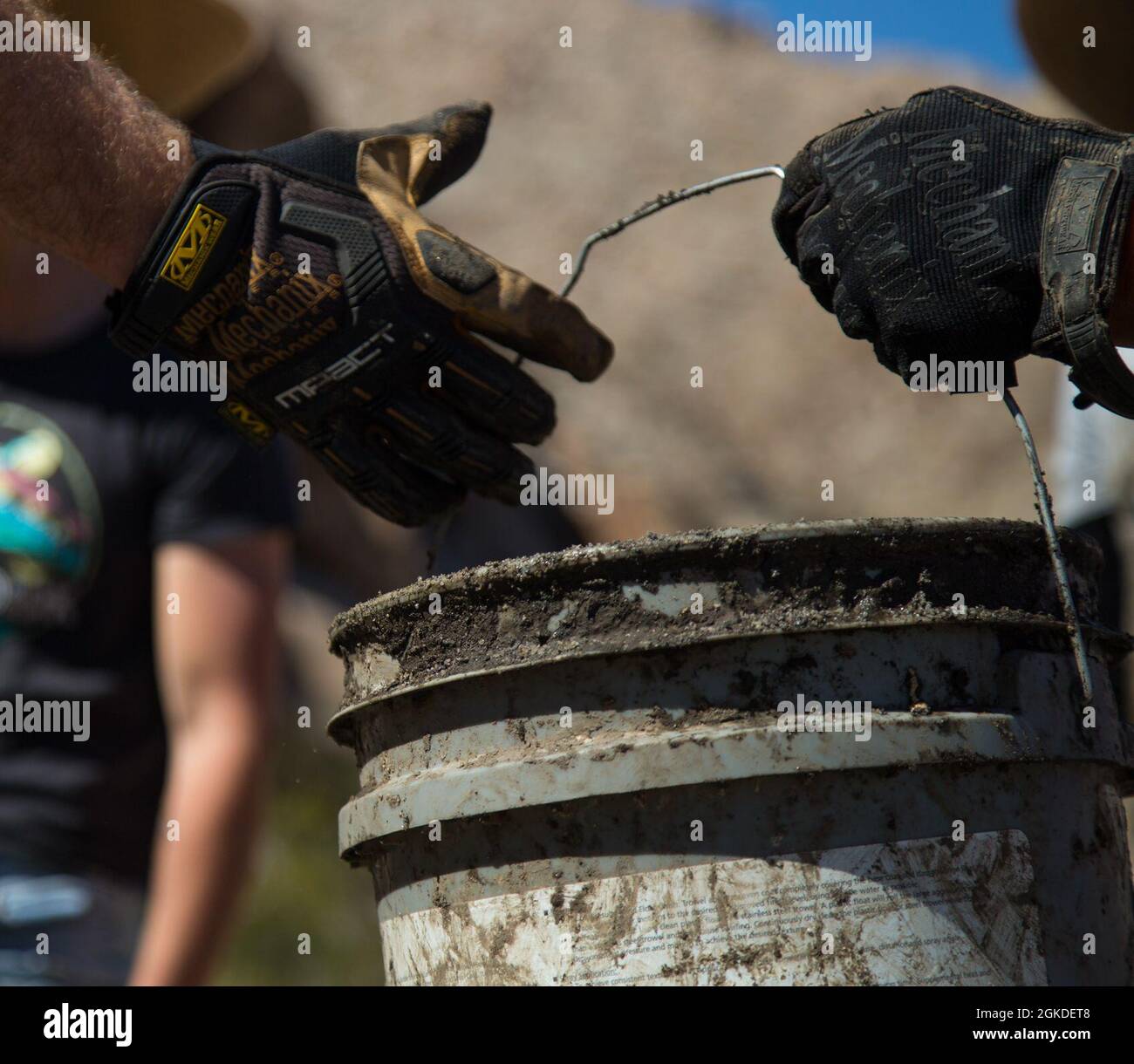 U.S. Marines with the Single Marine Program and civilians work together to help clear a Bighorn Sheep watering hole from built-up silt at the Betty Lee Tank in Yuma Ariz., Mar 20, 2021. The SMP sends volunteers to help with community efforts and build relations between the community and the Marine Corps. Stock Photo