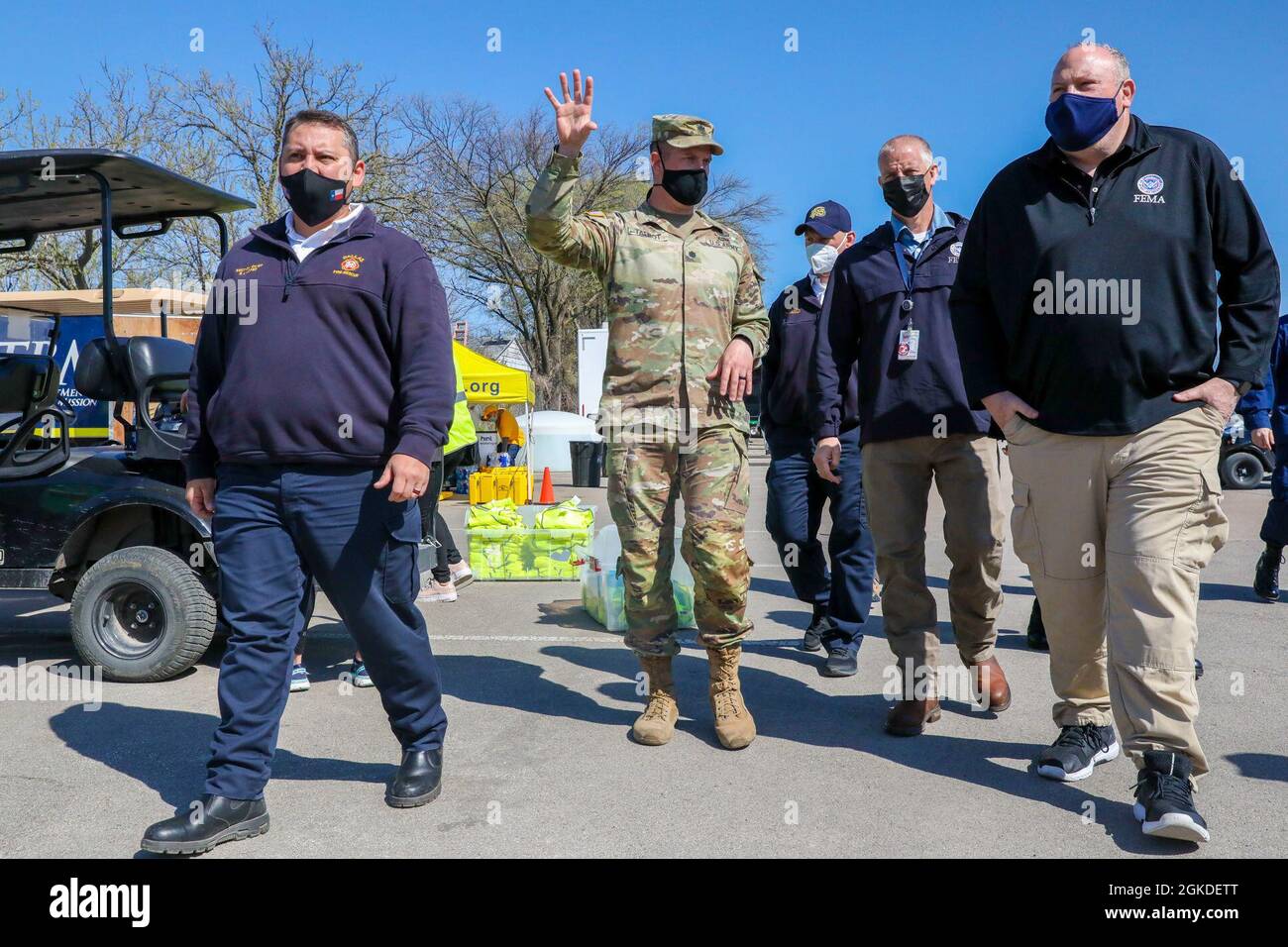 Stephan Lopez Jr. (far left), the section chief of Geospatial Intelligence and Analytics at Dallas Fire-Rescue, and U.S. Army Lt. Col. Nicholas Talbot (center left), 1st Combined Arms Battalion, 63rd Armor Battalion, 2nd Armored Brigade Combat Team, 1st Infantry Division, commander, escort Robert “Bob” Fulton (far right), the Acting Administrator of the Federal Emergency Management Agency (FEMA), on an on-site location tour at the Fair Park Community Vaccination Center (CVC) in Dallas, March 20, 2021. Through a federal validation process, it was determined that U.S. service members could assis Stock Photo