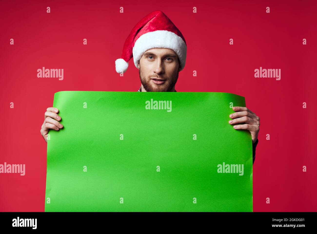 emotional man in a santa hat holding a banner holiday red background ...