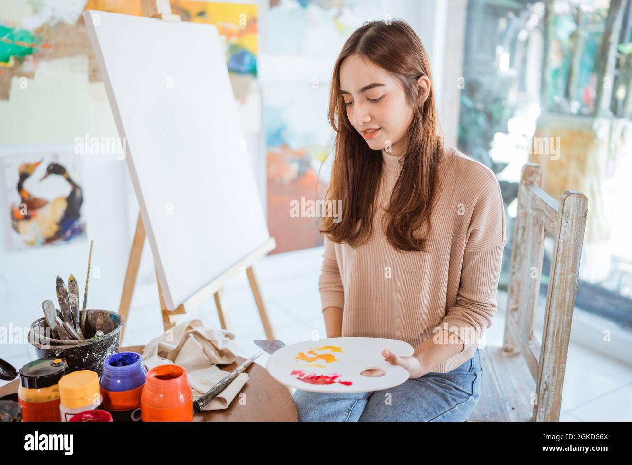asian female artist painting on canvas doing some art projects on her ...