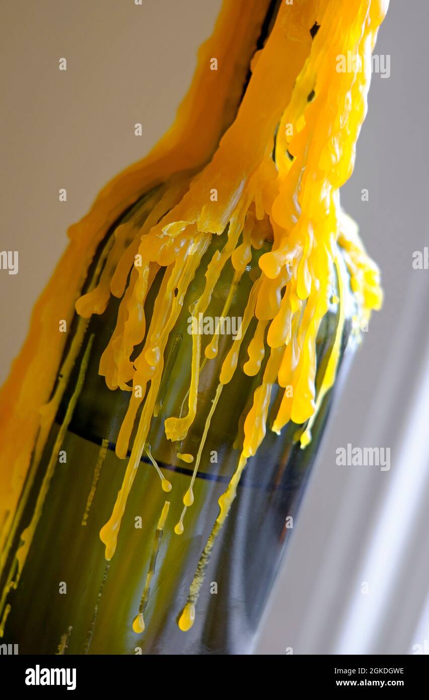 yellow candle wax running down glass wine bottle Stock Photo Alamy