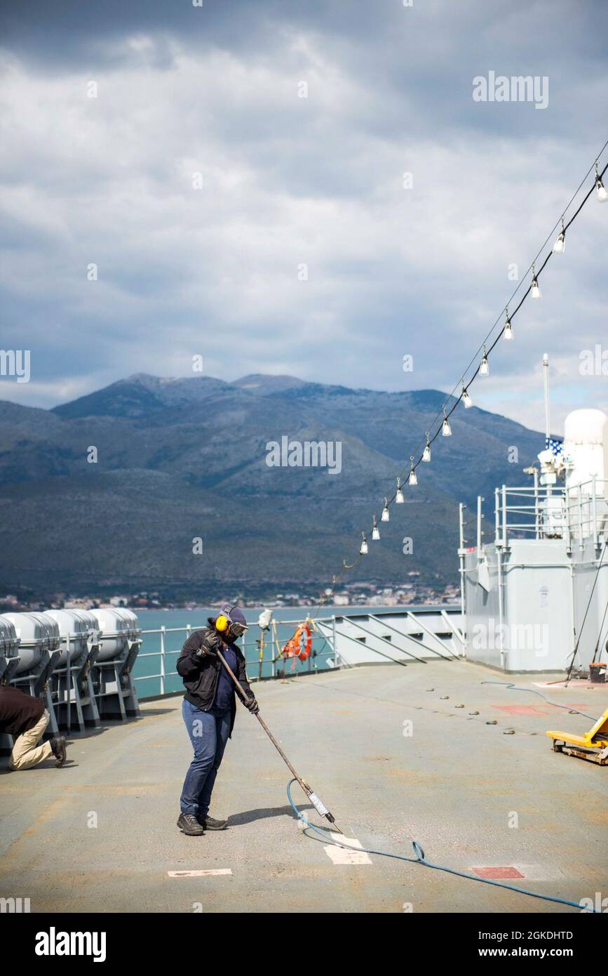 210322-N-EI510-0086 GAETA, Italy (March 22, 2021) A Military Sealift Command civil service mariner resurfaces the deck aboard the Blue Ridge-class command and control ship USS Mount Whitney (LCC 20) in Gaeta, Italy, March 22, 2021. Mount Whitney, forward deployed to Gaeta, Italy operates with a combined crew of Sailors and Military Sealift Command civil service mariners in the U.S. Sixth Fleet area of operations in support of U.S. national security interests in Europe and Africa. Stock Photo