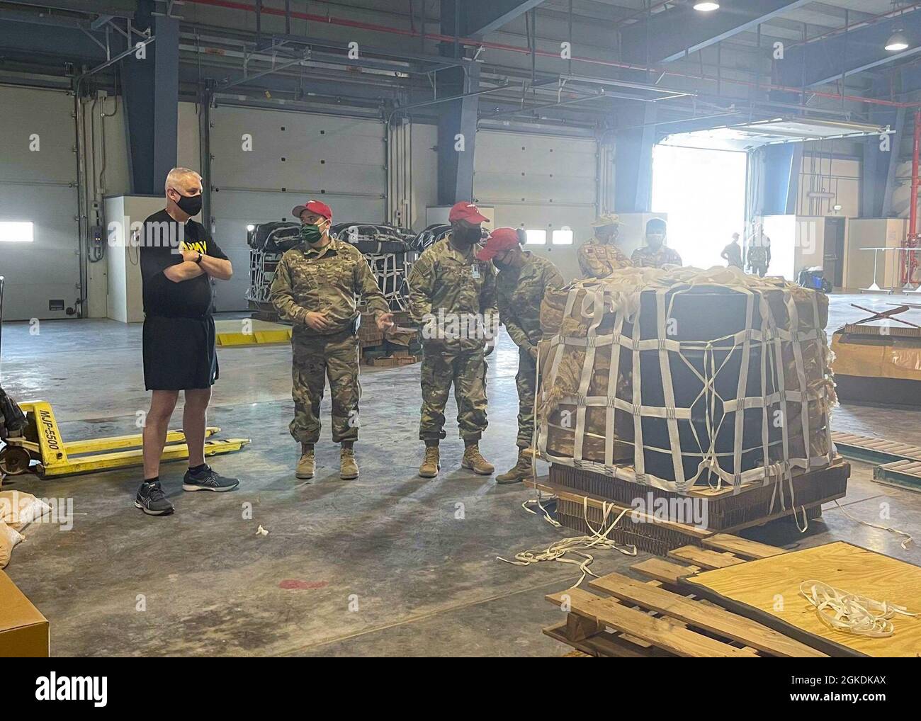 Maj. Gen. John P. Sullivan, commanding general, 1st Theater Sustainment Command, visits the riggers of the 151st Quartermaster Detachment at Al Udeid Airbase, Qatar, Mar. 22, 2021. The Soldiers were rigging fuel drum bundles and other equipment for airdrop as part of Exercise Impregnable Guard. The ‘Impregnable Guard’ military exercise, which is carried out annually, is part of the security measures undertaken by Qatar to host the 2022 World Cup and enhances military cooperation and exchange of expertise between participating forces. Stock Photo