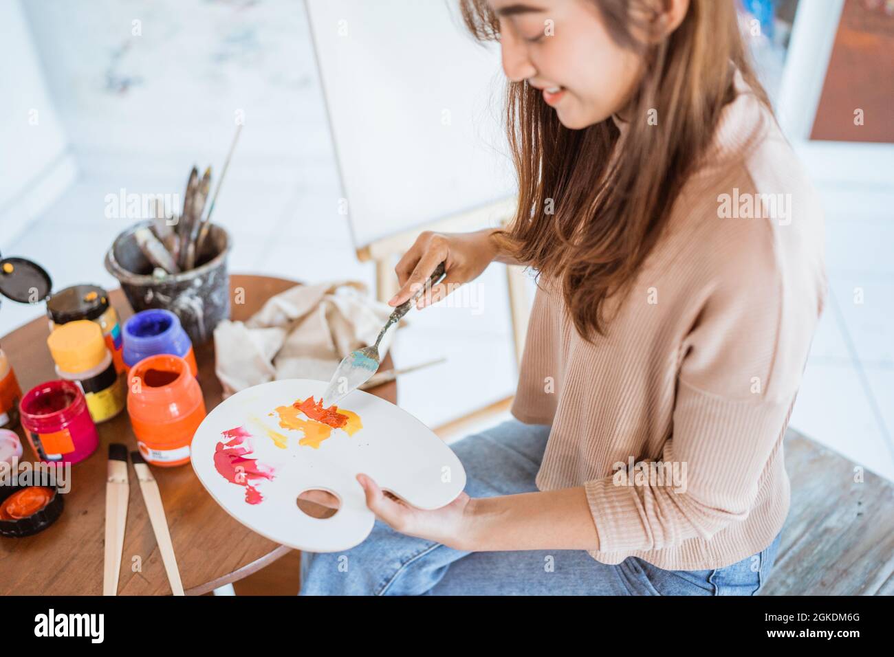 asian female artist painting on canvas doing art projects on her studio ...