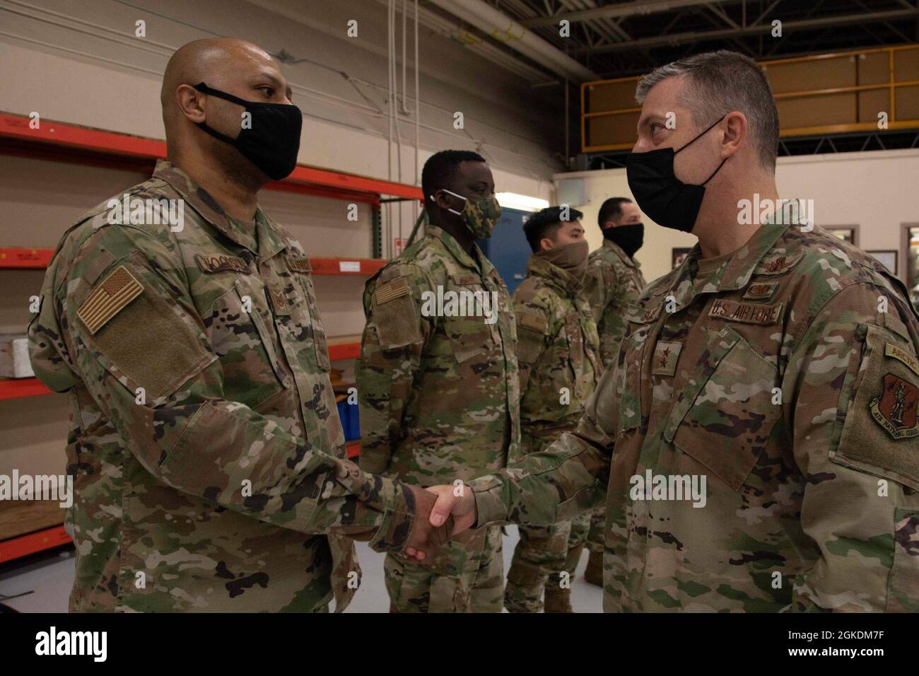 Maj. Gen. Torrence Saxe, adjutant general of the Alaska National Guard, right, awards Tech Sgt. Steven Woodson a coin during a visit to Eielson Air Force Base, Alaska, March 23, 2021. Stock Photo