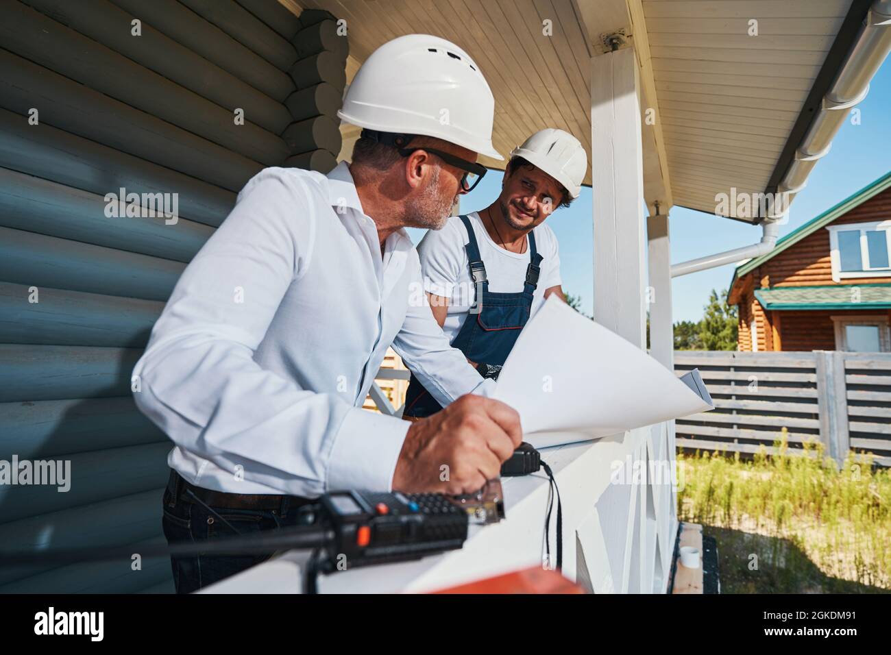 Worker and engineer looking at each other while reading drawings Stock Photo