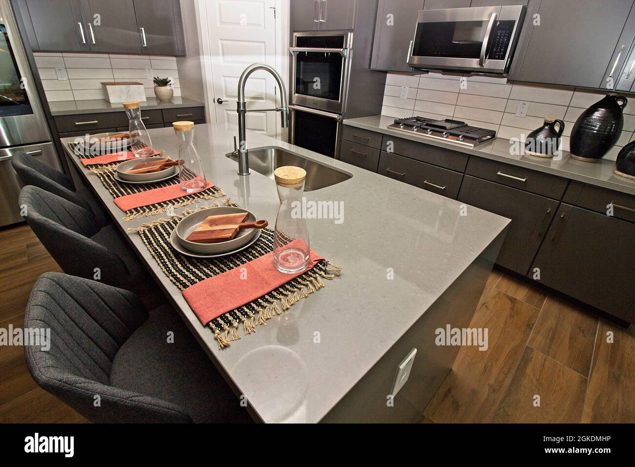 Kitchen Island Counter With Sink And Three Place Settings Stock Photo