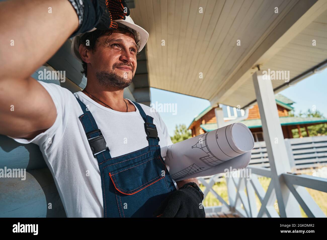Man adjusting his hard hat with right hand Stock Photo