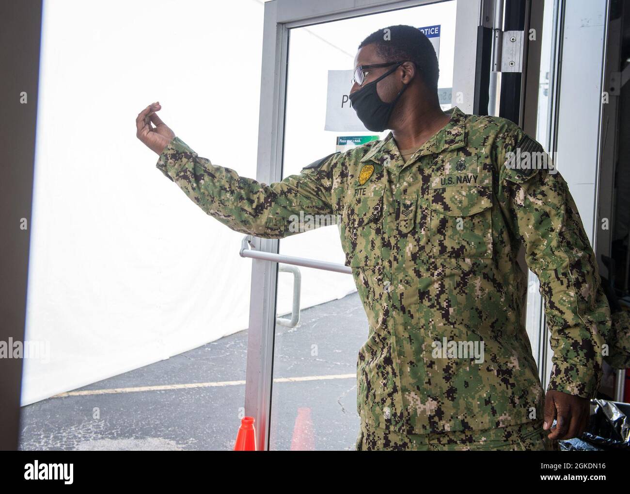 U.S. Navy Master-at-Arms 1st Class Michael Fite, a Norfolk, Virginia, native assigned to Navy Medicine Readiness and Training Command Jacksonville, directs people into the Community Vaccination Center in Jacksonville, Florida, March 23, 2021. U.S. Northern Command, through U.S. Army North, remains committed to providing continued, flexible Department of Defense support to the Federal Emergency Management Agency as part of the whole-of-government response to COVID-19. Stock Photo