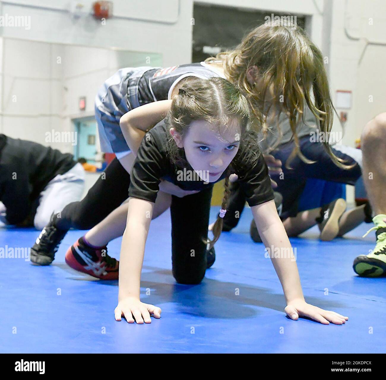 These wrestlers practice their moves at a youth wrestling team practice
