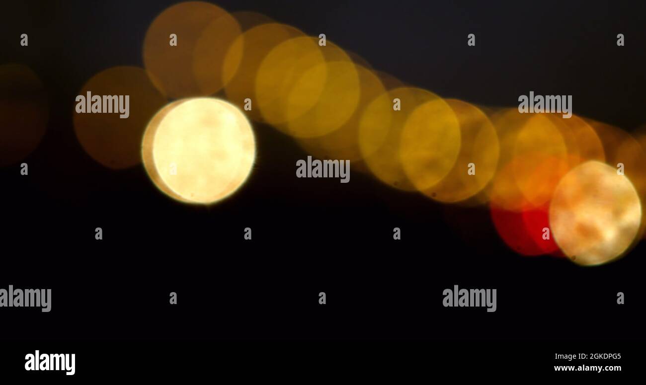 Digital image of glowing golden spots of light moving against against