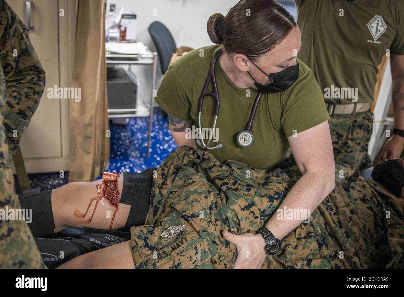 PACIFIC OCEAN (March 25, 2021) U.S. Navy Hospital Corpsman 1st Class Kayla Seim, with Combat Logistics Battalion, 11th Marine Expeditionary, provides medical care to a simulated casualty during a mass casualty exercise aboard the amphibious dock landing ship USS Pearl Harbor (LSD 52), March 25. U.S. Navy and Marine Corps integration training provides the Essex Amphibious Ready Group/11th MEU its first opportunity to plan, brief, execute multiple mission packages. The Essex ARG is underway conducting routine operations in U.S. Third Fleet. Stock Photo