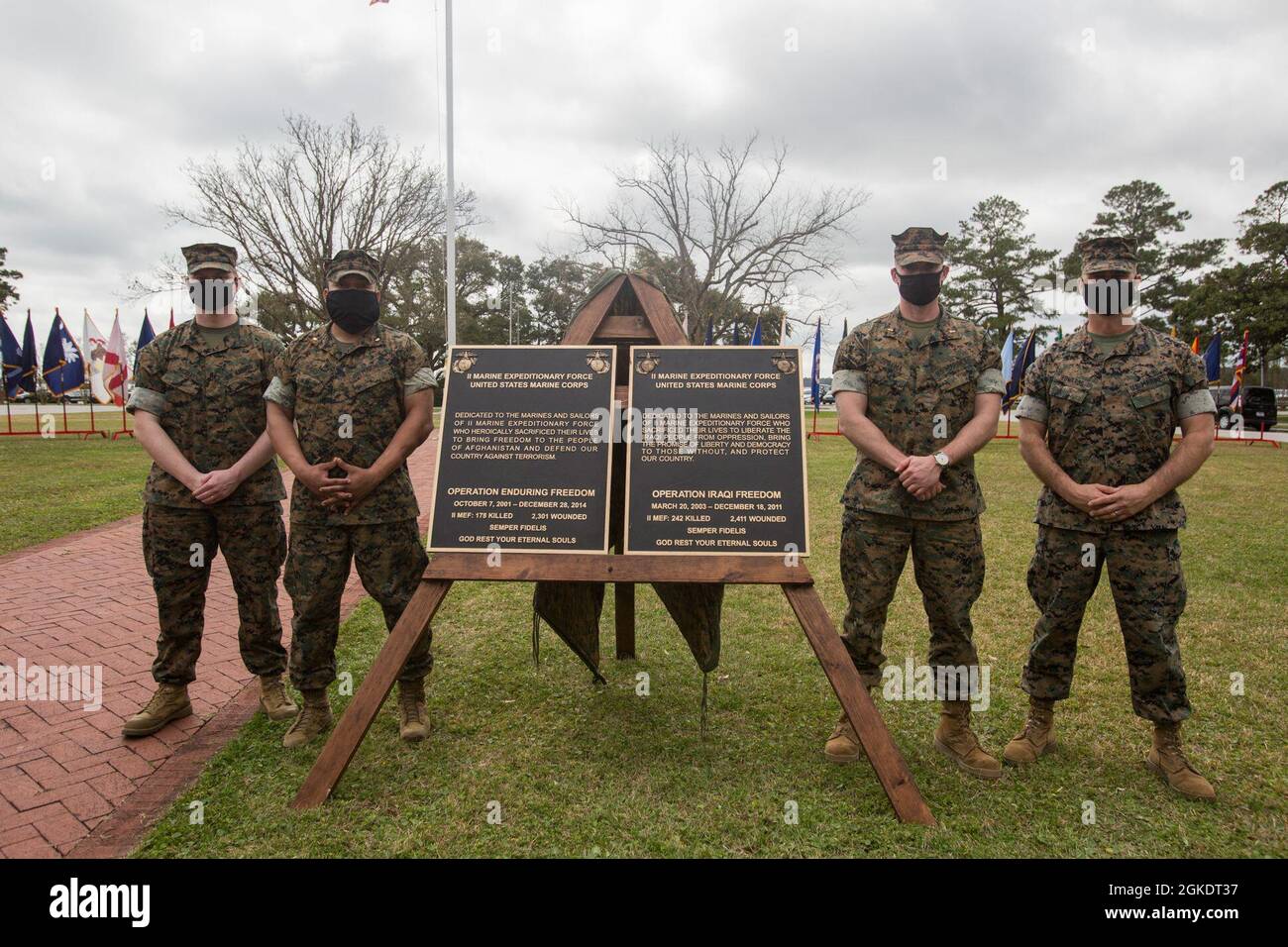 U.S. Marines who participated in Operation Iraqi Freedom and Operation Enduring Freedom with II Marine Expeditionary Force pose for a picture in front of a plaque after a dedication ceremony on Marine Corps Base Camp Lejeune, Mar. 24, 2021. This dedication ceremony allows II MEF to carry on the legacy of fallen Marines and sailors by honoring their sacrifice and commemorating their heroic achievement during OIF and OEF. Stock Photo