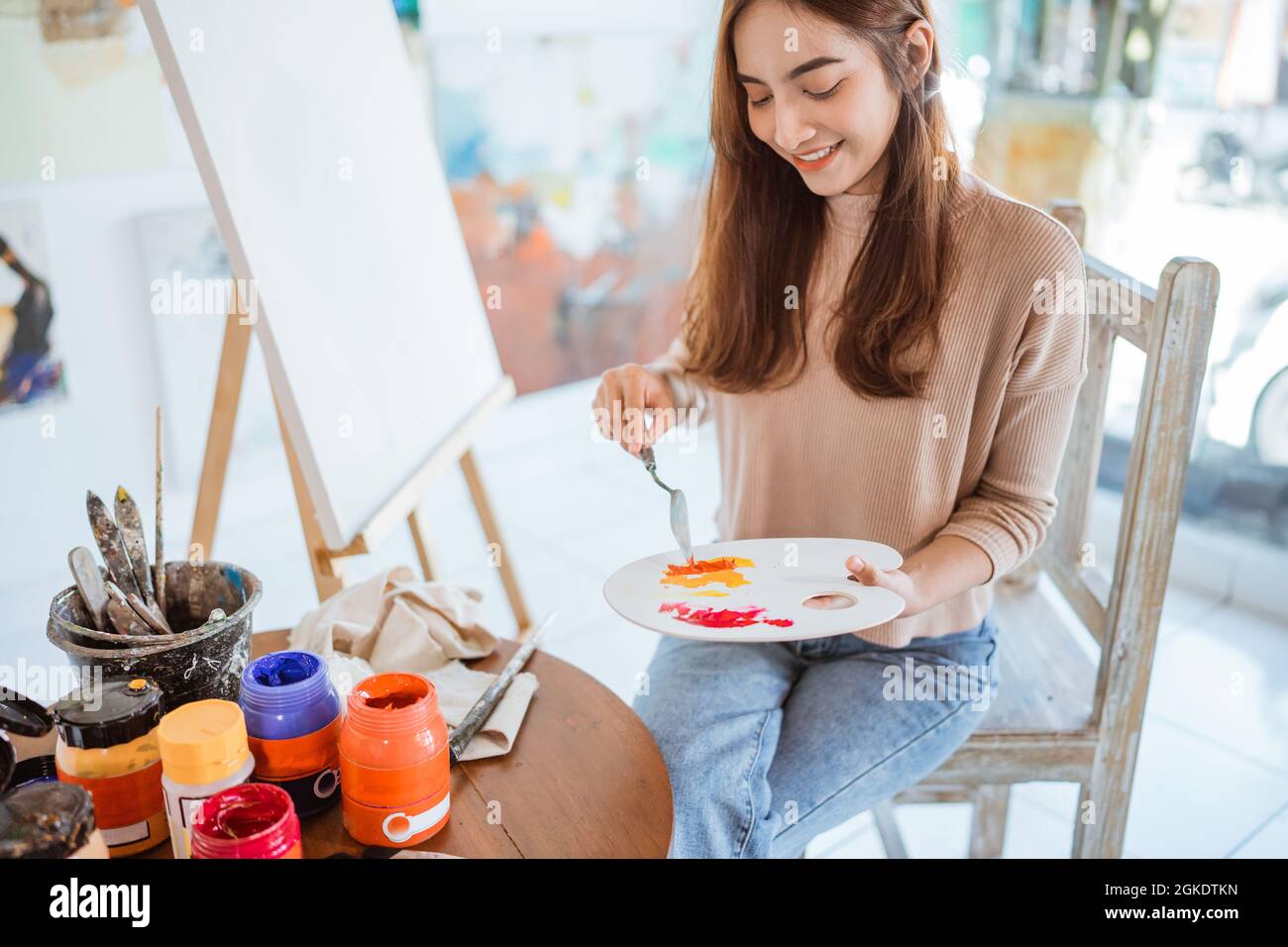 asian female artist painting on canvas doing some art projects on her ...