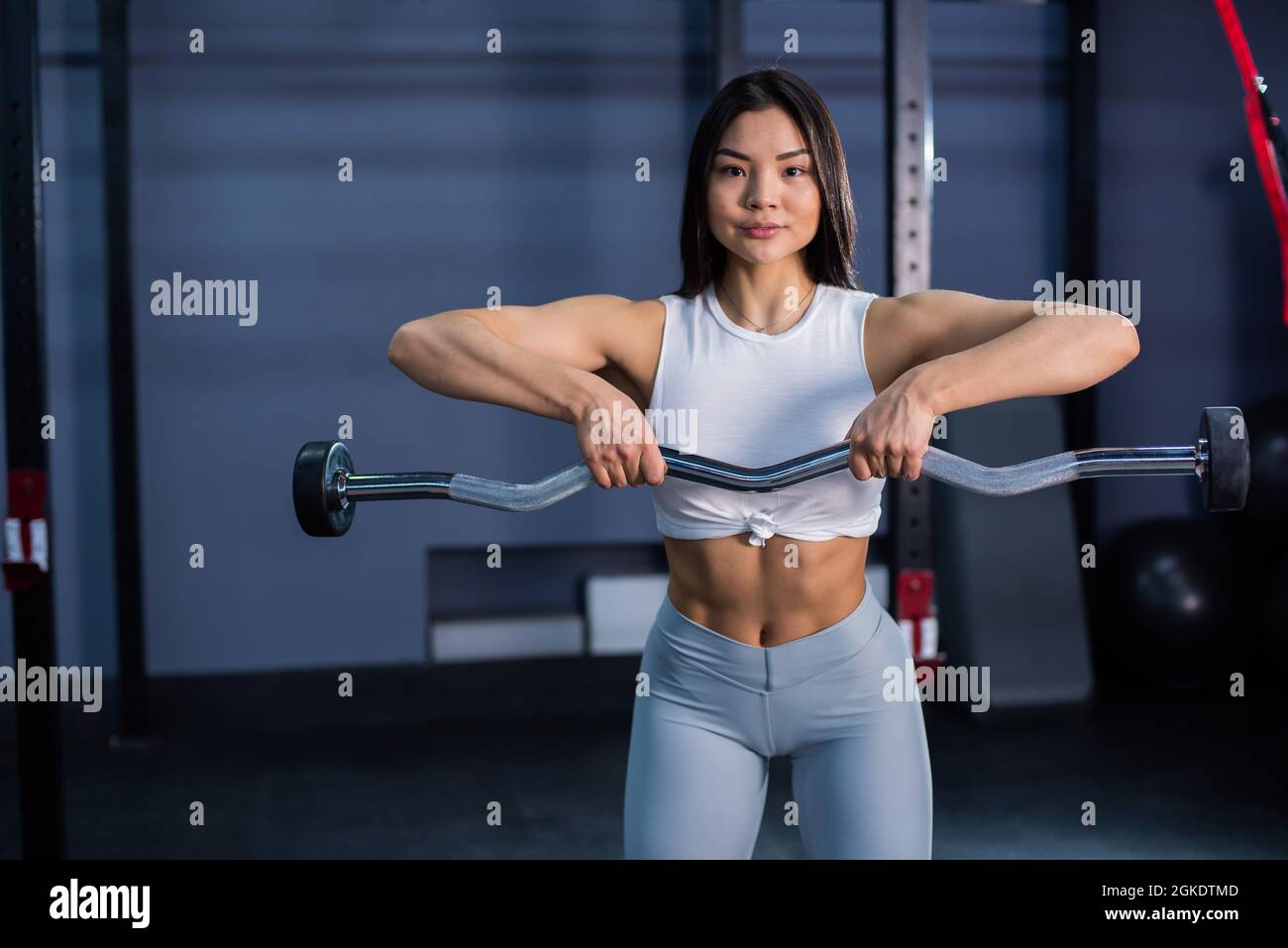Asian woman doing exercises with dumbbells in the gym Stock Photo - Alamy