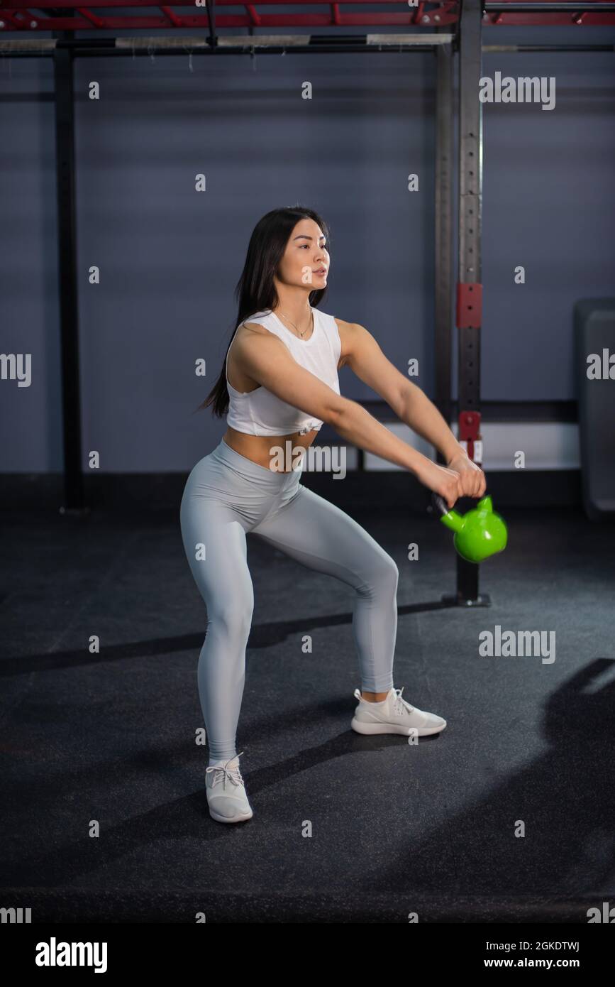 Asian woman doing exercises with dumbbells in the gym Stock Photo - Alamy