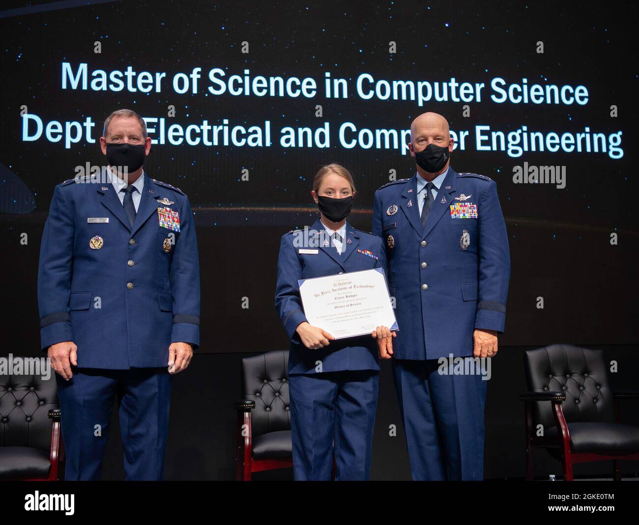 U.S. Space Force Gen. John W. Raymond, Chief of Space Operations, and Air Force Lt. Gen. James B. Hecker, Air University commander and president, presents Space Force 2nd Lt. Claire Badger with her Master of Science degree during the Air Force Institute of Technology graduation ceremony on Wright-Patterson Air Force Base, Ohio, March 25, 2021. The graduating class of more than 200 students included 34 Guardians earning their advanced degrees. Stock Photo