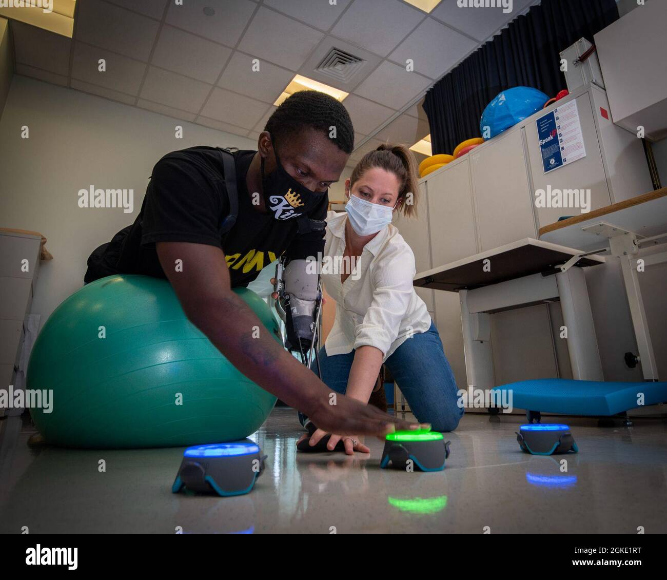 Aimee Toreno, Doctor of Occupational Therapy and certified hand therapist, helps patient Kayshawn Porterfield with a hand-eye coordination reaction time exercise at Brooke Army Medical Center’s Center for the Intrepid, Fort Sam Houston, Texas, March 25. 2021. Occupational therapists play a key role in the rehabilitation of upper extremity using individualized treatment plans to reduce pain, improve range of motion, restore strength, and maximize function. Stock Photo