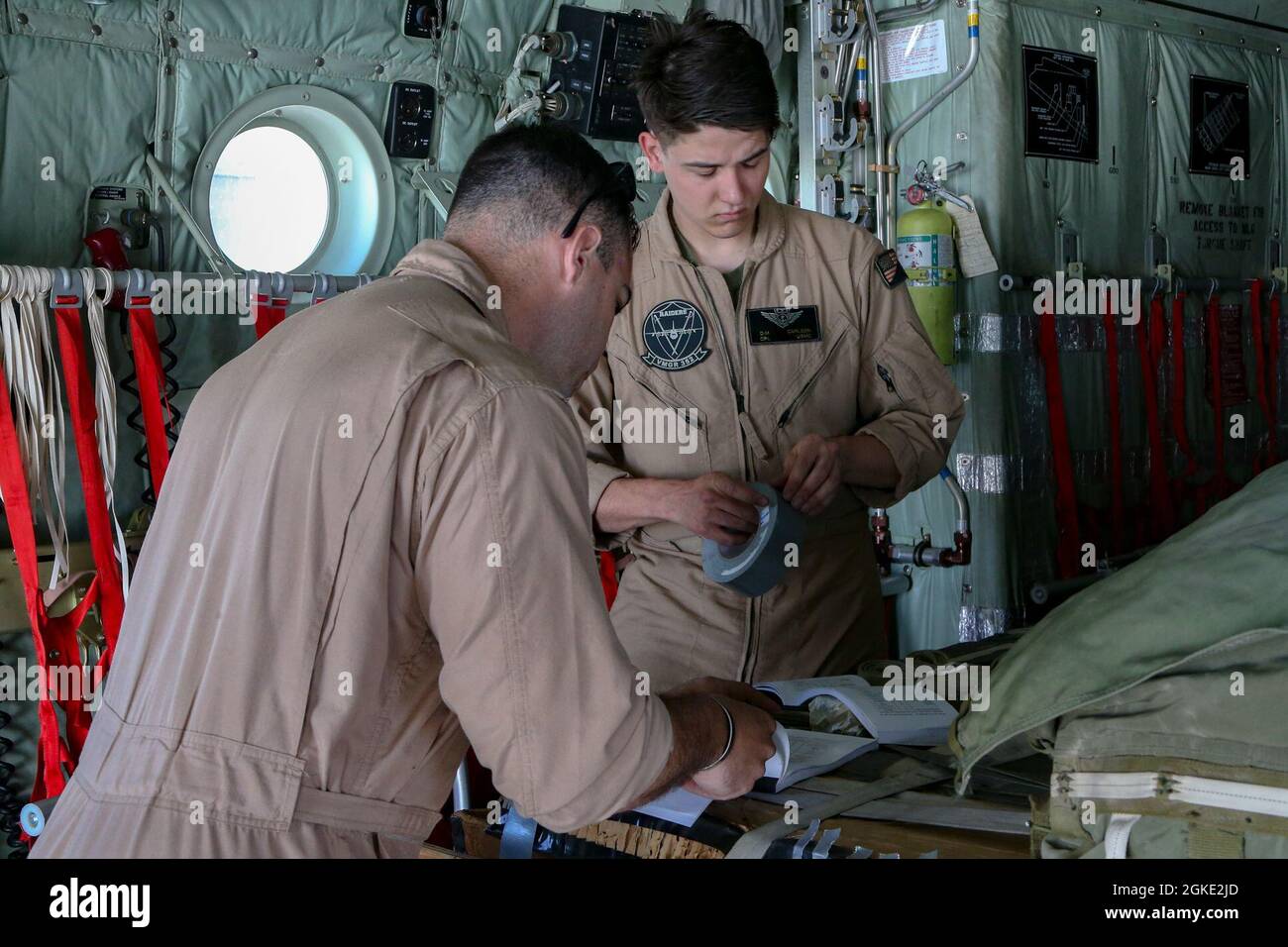 U.S. Marines, Staff Sgt. Timothy Leidecker, left, a loadmaster with Marine Aerial Refueler Transport Squadron 252, Marine Aircraft Group 14, 2nd Marine Aircraft Wing, and Cpl. Dillon Carlson, right, an aircrew master with Marine Aerial Refueler Transport Squadron 352, Marine Aircraft Group 11, 3rd Marine Aircraft Wing, prepare cargo, before conducting a heavy and combination airdrop, in support of Weapons and Tactics Instructor (WTI) course 2-21, at Marine Corps Air Station Yuma, Arizona, March 25, 2021. WTI is a seven-week training event hosted by Marine Aviation Weapons and Tactics Squadron Stock Photo