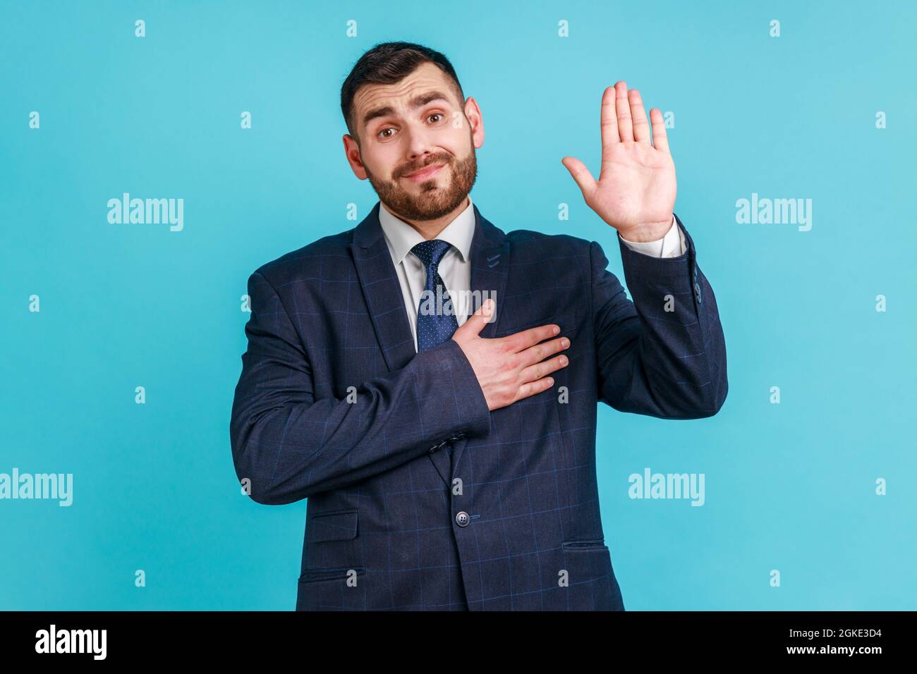 I promise to tell truth! Bearded man wearing official style suit standing raising hand and saying swear, making loyalty oath, pledging allegiance. Ind Stock Photo